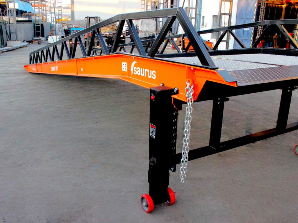 Detail hydraulické podpěrné nohy a zajišťovacího řetězu mobilní rampy Saurus